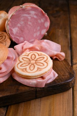 Tahta bir masada Mortadella ve Panino. Emilia Romagna bölgesindeki geleneksel İtalyan sandviçleri için çeşitli ekmekler..