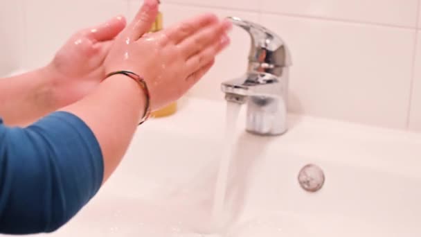 The child washes his hands with soap in the bathroom. The little girl observes hygiene and looks after herself. Necessary actions during colds and viruses. — Stock Video