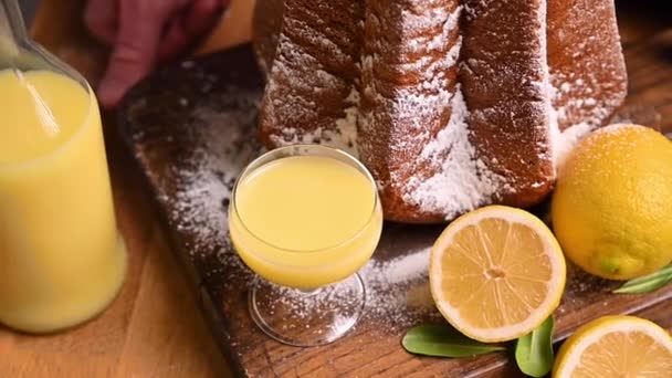 Limoncello avec un verre sur la table et une pâte douce en forme d'étoile saupoudrée de sucre glace. — Video