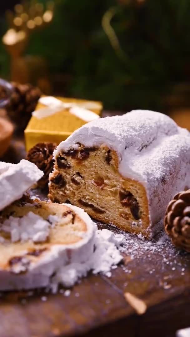 Stollen na drewnianym tle. Tradycyjny niemiecki słodki chleb z suszonymi owocami i marcepanem na Boże Narodzenie. — Wideo stockowe