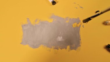 Panton 2021 trendi sarı ve gri renklerde. Sarı arkaplanda gri boyalar olan soyut resim.