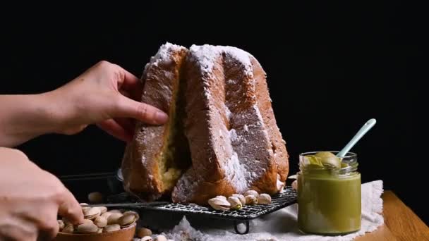 Pandora es un pan italiano de Navidad. Pasteles dulces del norte de Italia con crema de pistacho. La mujer corta un pedazo de Pandoro. — Vídeo de stock