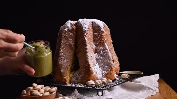 Śmietana pistacjowa i tradycyjny słodki chleb Pandoros. Włoskie wypieki świąteczne z musem orzechowym i cukrem pudrem. — Wideo stockowe