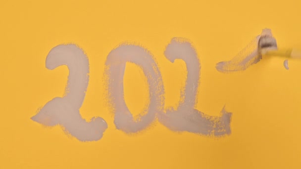 Data 2021, pintado com uma escova em tintas cinza em um fundo amarelo. Padrão de cores tendências para o ano novo. — Vídeo de Stock