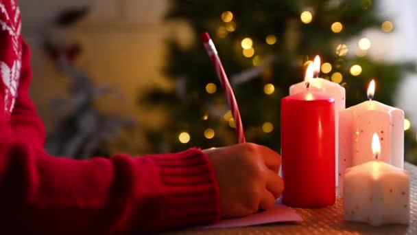 Dívka píše dopis Santa Clausovi v sladkém domově vyzdobeném k Vánocům. — Stock video