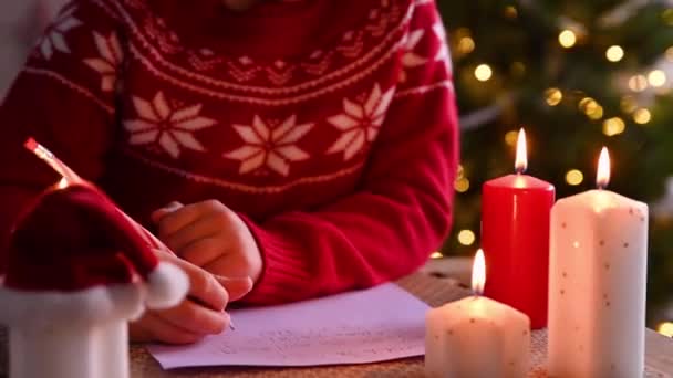 Κοριτσάκι που γράφει ένα γράμμα στον Άγιο Βασίλη σε ένα γλυκό σπίτι διακοσμημένο για τα Χριστούγεννα.. — Αρχείο Βίντεο