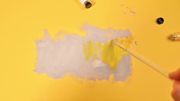 Panton 2021 tendência em cores amarelas e cinza. Imagem abstrata com tintas cinza sobre um fundo amarelo. — Vídeo de Stock