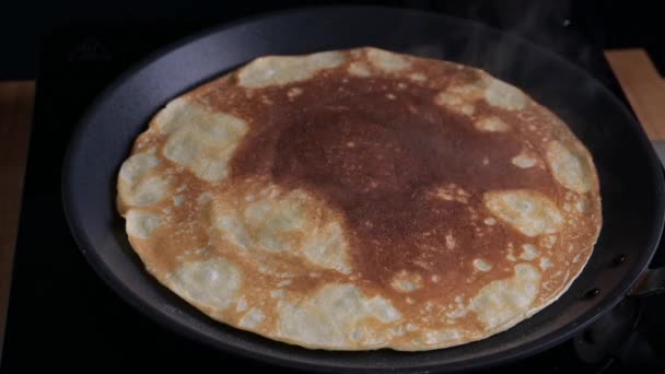 Rysk pannkaka är stekt i en kastrull. Processen att göra tunna pannkakor för karneval. — Stockvideo