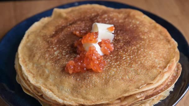 Ryska tunna pannkakor med laxkaviar och smör. Traditionell mat för semestern — Stockvideo