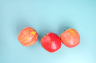 Mavi arka planda güzel kırmızı kırsal elmalar. Metin için boş alan.