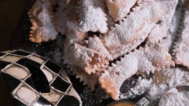 Sfrappole or chiachiere or angel wings and aromatic coffee on a woody background. Carnival food TYPICAL and carnival mask. Traditional sweet crisp pastry deep-fried and sprinkled with powdered sugar. — Stock Video