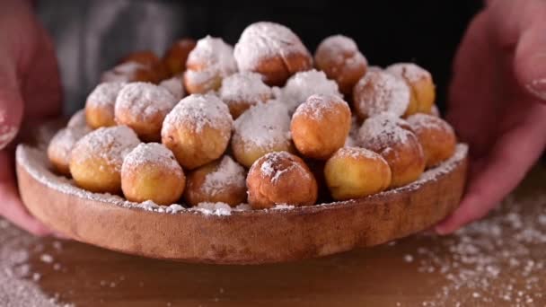 Castagnole al horno con azúcar en polvo. El polvo se vierte en productos horneados. Pasteles dulces tradicionales durante el período de carnaval en italia. Galletas redondas con azúcar para el carnaval de Venecia — Vídeo de stock