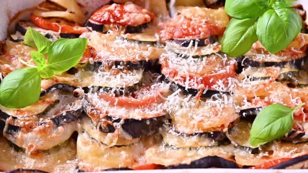 Nourriture italienne traditionnelle. Aubergine cuite au four, tomates avec sauce, parmesan et basilic. Nourriture rustique pour une alimentation saine. Légumes pour le déjeuner. — Video