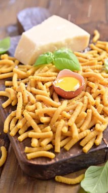 Tavuk suyunda pişirilmiş makarna, taze makarna. Brodo 'da Passatelli. Yumurtadan yapılmış bir makarna, rendelenmiş parmesan peyniri. Tipik Emilia Romagna. Parmesan döküldü. Sosyal medya videosu, dikey