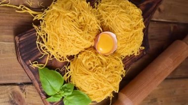 Tagliatelle makarnası incedir. Melek Saçlı geleneksel İtalyanca. İtalyan yumurtalı makarna, ev yapımı ve ahşap bir masada taze. İtalya 'nın kuzeyinin kırsal mutfağı. Sosyal ağlar için dikey video.