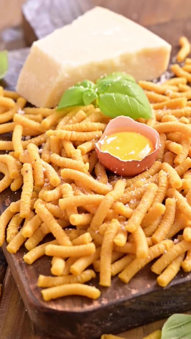 Pasta cooked in chicken broth , fresh pasta. Passatelli in brodo and pouring cheese. A pasta formed of eggs, grated Parmesan cheese. Typical for Pesaro, Urbino and Emilia Romagna. Slow-motion — Stock Video