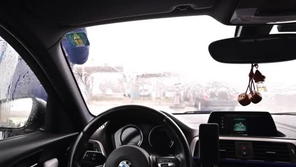 Bolonya, İtalya 7 Şubat 2021. Otomobil yıkamada lastik yıkayan koruyucu maskeli bir adam arabayı yıkar. Araba servisi.. — Stok video