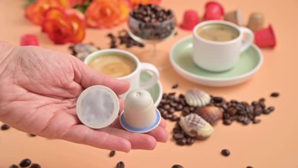 Capsules for an espresso machine in hand. Aromatic Italian coffee with beautiful crema. Arabica coffee beans for the preparation of a traditional drink. — Stock Video