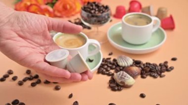 Elinde bir espresso makinesi için kapsüller. Güzel kremalı Aromatik İtalyan kahvesi. Geleneksel bir içecek hazırlamak için Arap kahvesi..