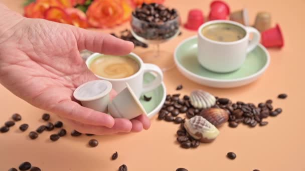 Capsules voor een espressomachine in de hand. Aromatische Italiaanse koffie met mooie crema. Arabica koffiebonen voor de bereiding van een traditionele drank. — Stockvideo