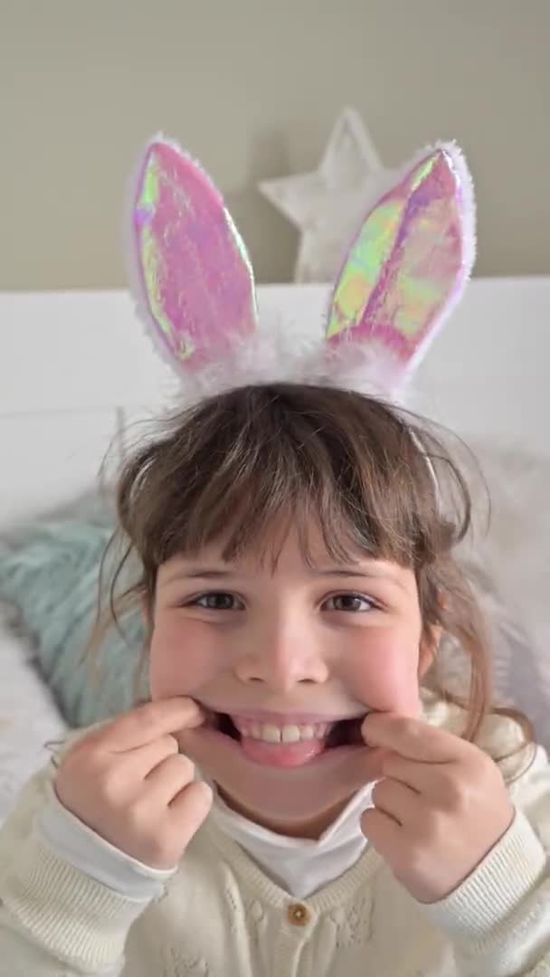 兔子耳朵里的快乐小女孩很开心。这孩子鬼鬼祟祟的,玩得很开心.慢动作。垂直视频，用于社交网络 — 图库视频影像