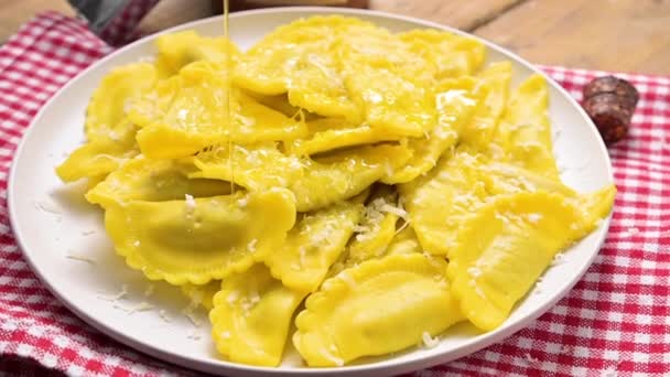 Tartollini med ost eller kött på en tallrik med riven parmesan och olivolja hälls. Traditionell maträtt i Italien, Emilia Romagna regionen. Hemlagad pasta. Italienskt kök — Stockvideo