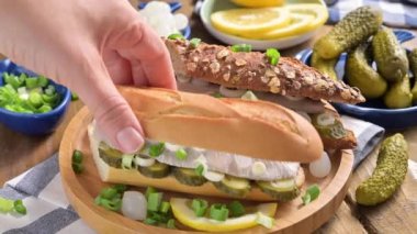 Hollanda ringası. Hollanda ringa balıklı tost, soğan, turşu. Geleneksel köy mezeleri ve deniz ürünleri. Hollanda 'da popüler yiyecekler.