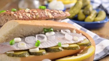 Hollanda ringası. Hollanda ringa balıklı tost, soğan, turşu. Geleneksel köy mezeleri ve deniz ürünleri. Hollanda 'da popüler yiyecekler. El bir sandviç alır..
