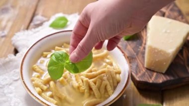 Çorbada Passatelli, tavuk suyunda pişirilmiş makarna. Ekmek kırıntısı, yumurta ve rendelenmiş parmesan peynirinden yapılmış bir makarna. Tipik Pesaro, Urbino ve Emilia Romagna. Yatay çekim.