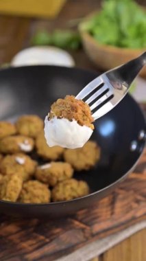 Çatal servis ediyorum. Taze vejetaryen falafel. Kızarmış falafel köfteleri kızartma tavasında. Lezzetli sağlıklı yiyecekler, Mısır ve Asya için geleneksel. Yüksek kaliteli FullHD görüntüler. Sosyal ağlar için dikey video.
