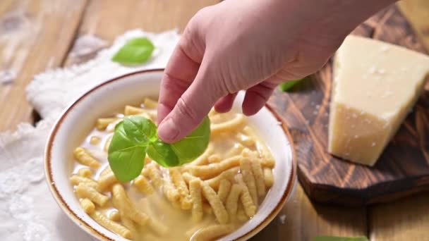 Çorbada Passatelli, tavuk suyunda pişirilmiş makarna. Ekmek kırıntısı, yumurta ve rendelenmiş parmesan peynirinden yapılmış bir makarna. Tipik Pesaro, Urbino ve Emilia Romagna. Yatay çekim. — Stok video