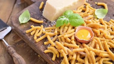 Tavuk suyunda pişirilmiş makarna, taze makarna. Brodo 'da Passatelli. Yumurtadan yapılmış bir makarna, rendelenmiş parmesan peyniri. Tipik Emilia Romagna. Parmesan döküldü. Sosyal medya videosu, dikey