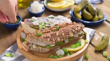 Hollanda ringası. Hollanda ringa balıklı tost, soğan, turşu. Geleneksel köy mezeleri ve deniz ürünleri. Hollanda 'da popüler yiyecekler.