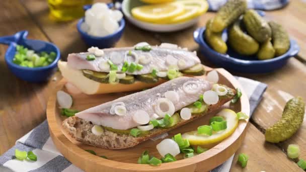 Arenque holandés. Brindis con arenque holandés, cebollas, pepinillos. Aperitivo rústico tradicional con mariscos. Comida popular en los Países Bajos. — Vídeos de Stock