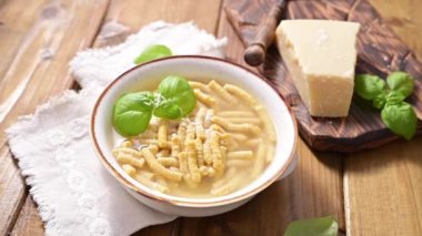 Çorbada Passatelli, tavuk suyunda pişirilmiş makarna. Ekmek kırıntısı, yumurta ve rendelenmiş parmesan peynirinden yapılmış bir makarna. Tipik Pesaro, Urbino ve Emilia Romagna. Yatay çekim.