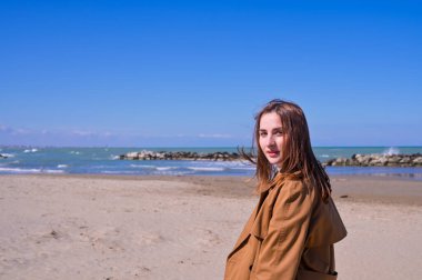 Bir plajın önünde duran bir adam. Güzel genç kız deniz kıyısında yürüyor. Duyguların dışavurumu. Turizm ve seyahat kavramı. Yüksek kalite fotoğraf