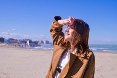 Bir plajın önünde duran bir adam. Güzel genç kız deniz kıyısında yürüyor. Duyguların dışavurumu. Turizm ve seyahat kavramı. Yüksek kalite fotoğraf