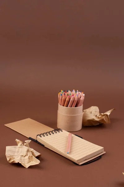 Zerknüllte Papierkugeln und ein Notizbuch mit einer Hand für Notizen — Stockfoto