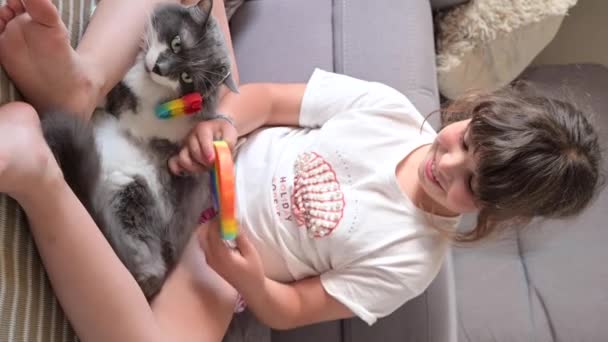 Kleines Mädchen spielt mit Pop it sensorischem Spielzeug. Das Baby klickt auf bunte regenbogenweiche Silikonblasen. — Stockvideo