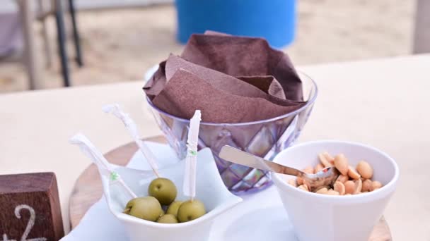 Aperitivos para un aperitivo en un bar de playa en Italia. Aceitunas y crutones para estráter con bebidas alcohólicas al aire libre. — Vídeo de stock