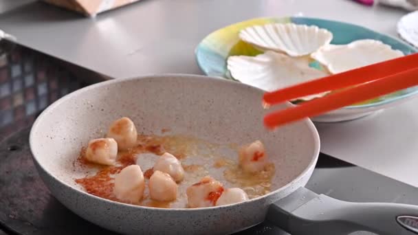 Şef sağlıklı gurme yemekleri hazırlıyor, tavada kızartılmış deniz tarakları. Geleneksel bir Fransız yemeği ve İtalyan deniz yiyeceği. — Stok video
