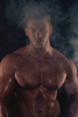 Seksi spor kaslı, kaslı adam beyaz havluyla siyah izole font arka planda dumanlı.