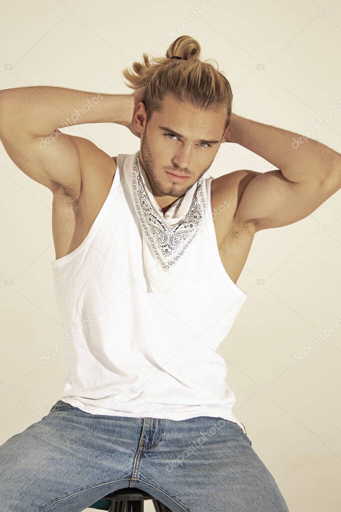 Sexy sport muscle strongface blond guy with long hair in denim blue jeans and white t-shirt on black isolated  font background