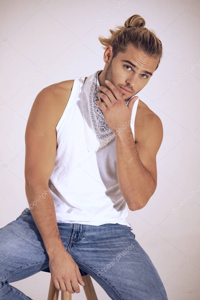 Sexy sport muscle strongface blond guy with long hair in denim blue jeans and white t-shirt on black isolated  font background