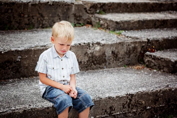 Little Boy crying  sitting on stone steps in park. Loneliness, m — Stock Photo, Image