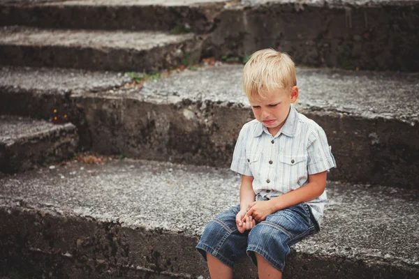 Little Boy crying  sitting on stone steps in park. Loneliness, m — Stock Photo, Image