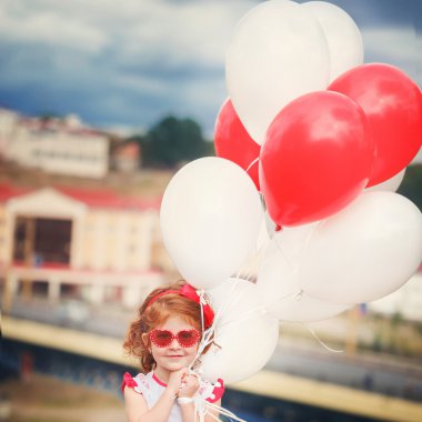 Kırmızı ve beyaz balon p küçük güzel kıvırcık kız