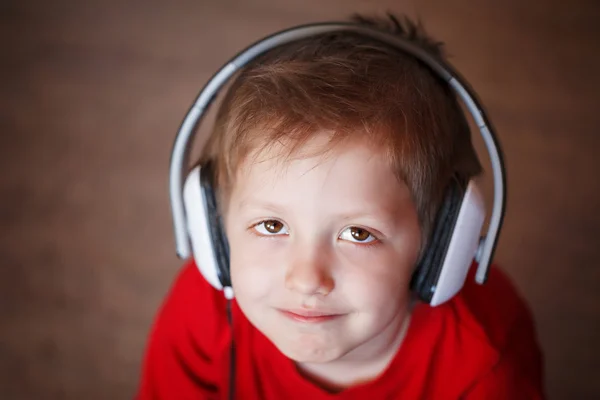 Primer plano Retrato de un niño sonriente escuchando música en la cabeza —  Fotos de Stock
