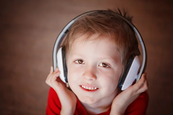 Primer plano Retrato de un niño sonriente escuchando música en la cabeza —  Fotos de Stock