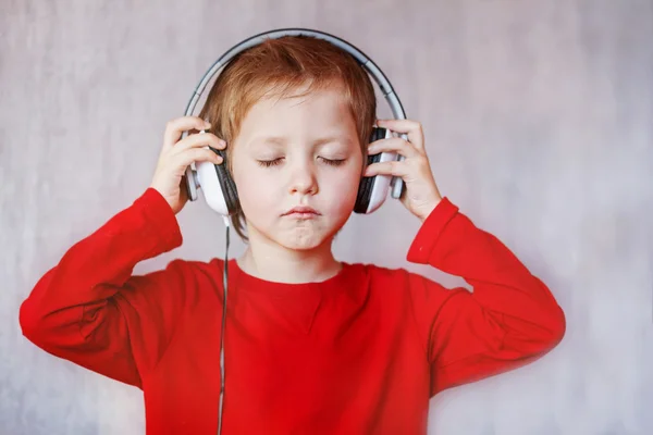 El chico escucha música en casa. Niño con auriculares . —  Fotos de Stock